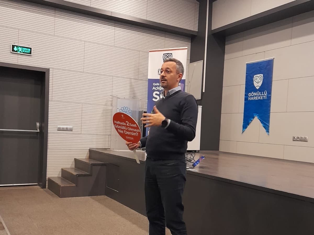 Sertaç Şipka, Gönüllü Hareketi flamasının önünde gönüllü oryantasyonunda konuşurken