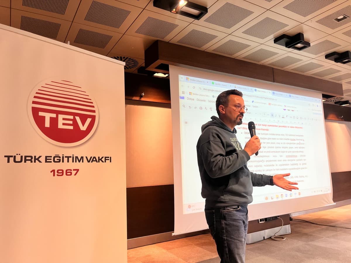 Sertaç Şipka, Türk Eğitim Vakfı şubeler çalıştayında elinde mikrofonla sunum yaparken